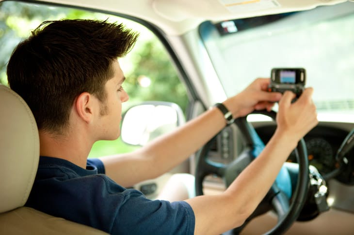Model good driving behavior. Photo: teen texting behind the wheel of a car.