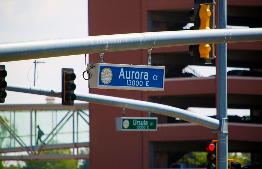 Street signs at a stop light in Aurora, Colorado with cross streets of Aurora Ct. and Ursula St.